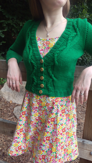 A cropped and cabled v-neck cardigan with three-quarter sleeves