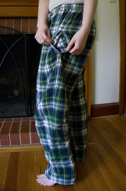 Side view of the tartan pajama pants with the pocket pulled open to reveal tartan pocket bags