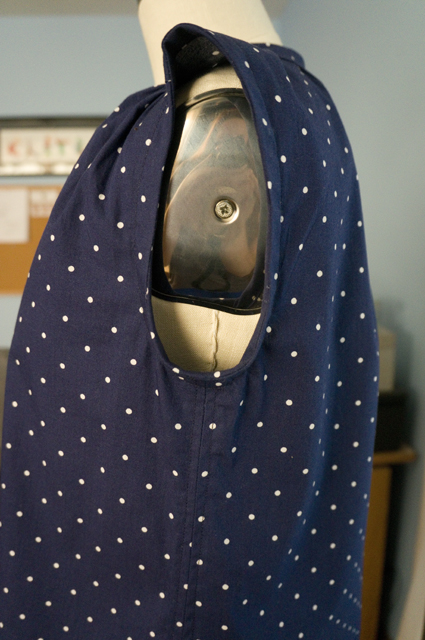 A close-up of the armhole and side seam of a woman's sleeveless summer top