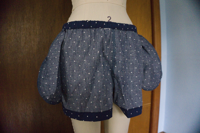 A pair of pajama shorts turned inside-out on a dress form to reveal in-seam pocket bags and the stitching throughout