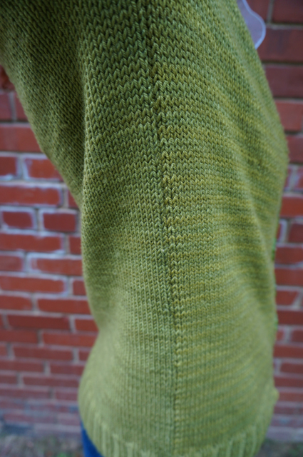 A close-up up of the side seam of Caitlyn's CustomFit Stonington, showing how the yarn's dye lots differ on the front and back